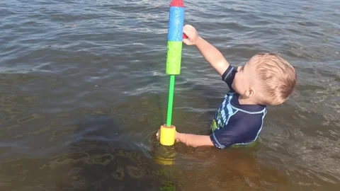 Summer joy in pond, child playing with water gun in river in summer,rest time. Stock Footage 246639184