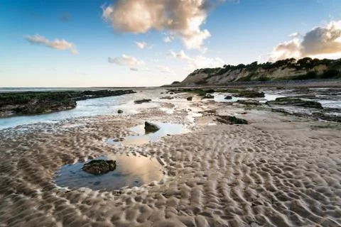 Summer landscape with rocks on beach during late evening and low sunlight Stock Photos