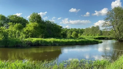 Summer landscape with a small river, blue sky and fluffy white clouds Stock Footage 220913497