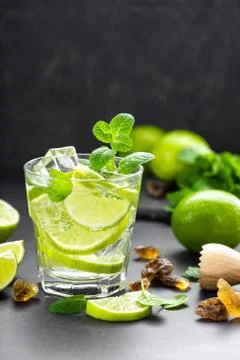 Summer mint lime refreshing cocktail mojito with rum and ice in glass on black b Stock Photos