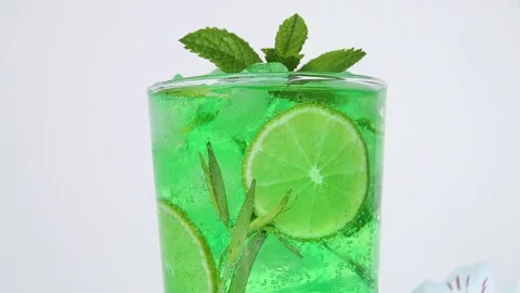 Summer mojito cocktail lemonade ice, tarragon, lime, mint, bubbles move glass Stock Footage 132585341