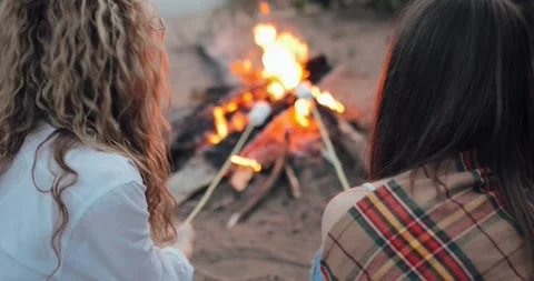 Summer night on the sand beach by the ocean, the bright burning fire, two girls Stock Footage 132816124