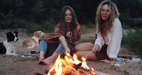 Summer night on the sand beach by the ocean, the bright burning fire, two girls Stock Footage 132816380