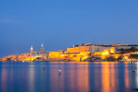 Summer night view of Valetta profile over sea. Long exposure. Illuminated Stock Photos
