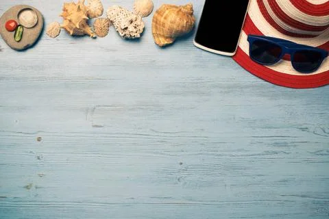 Summer objects for vacation Straw hat sunglasses smartphone among sea shel... Foto stock