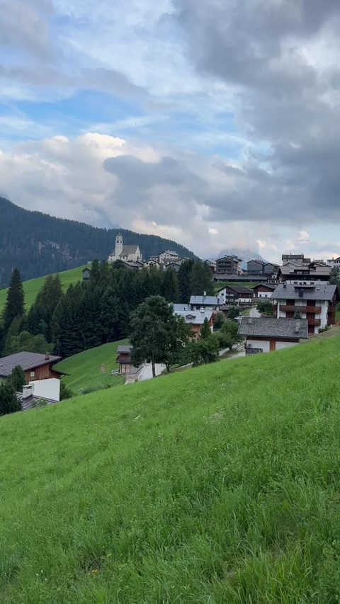 Summer panoramic view of Colle Santa Lucia village surrounded by green alpine Stock Footage 334793387