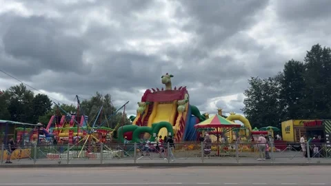 Summer party on the town square with inflatable trampolines and attractions Stock Footage 303977807