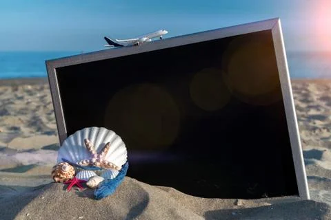 Summer pattern background. Starfish, seashells, toy plane and globe near blac Stock Photos
