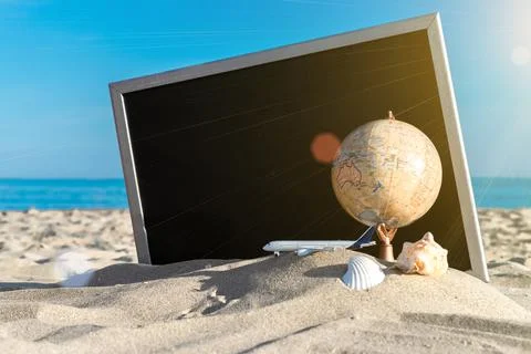 Summer pattern background. Starfish, seashells, toy plane and globe near blac Stock Photos