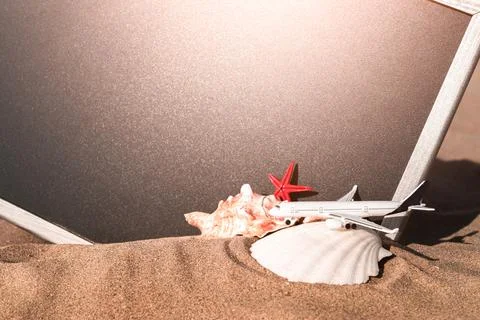 Summer pattern background. Starfish, seashells, toy plane and globe near blac Stock Photos