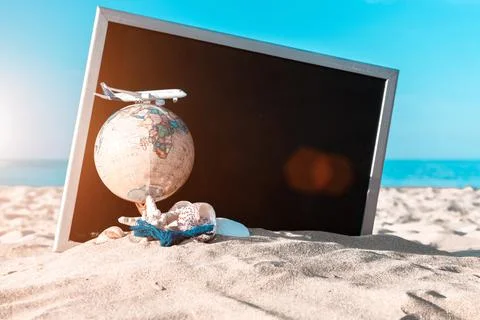 Summer pattern background. Starfish, seashells, toy plane and globe near blac Stock Photos