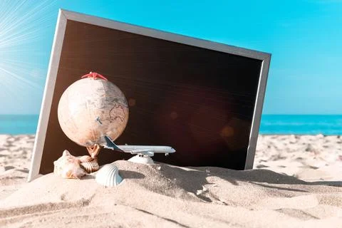 Summer pattern background. Starfish, seashells, toy plane and globe near blac Stock Photos