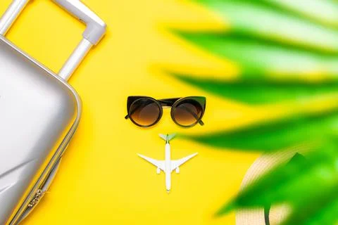 Summer pattern background. Suitcase, sunglasses with palm leaves and straw ha 스톡 사진