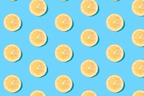Summer pattern of yellow lemon slices on light-mint background Stock Photos