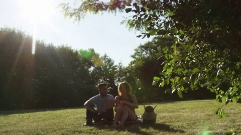 Summer Picnic Date Mixed Ethnicity Man and Woman Backlit Slow Motion Under A Stock Footage 82599853