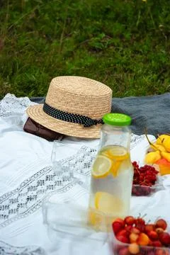 Summer picnic setting with straw hat and refreshing lemonade Stock Photos