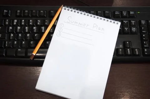 Summer plan. A notepad with notes for the summer is on a computer keyboard. Stock Photos