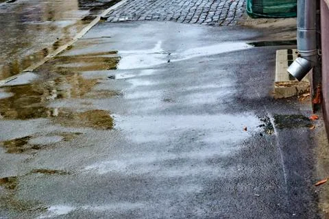 Summer rain. Falling rain. Raindrops. Puddles with bubbles on the pavement. W Stock Photos