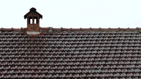 Summer rain falling on the red tile roof and chimney Stock Footage 83525344