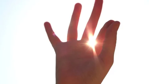 Summer rays of sunlight shine through child’s hand, close-up  Vídeo Stock 76930317