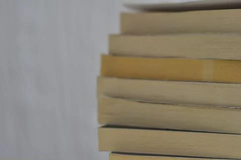 Summer reading concept: stack of old books in front of white wall Stock Photos
