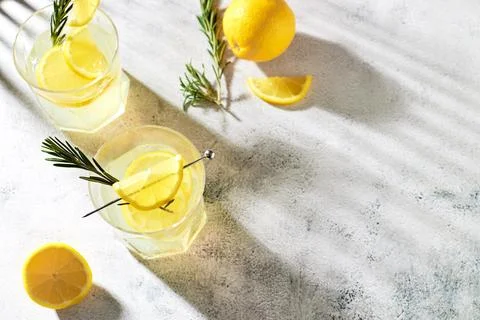 Summer refreshing drinks with fresh lemon slices and rosemary sprigs. Alcoholic Stock Photos