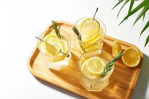 Summer refreshing drinks with fresh lemon slices and rosemary sprigs. Alcoholic Stock Photos