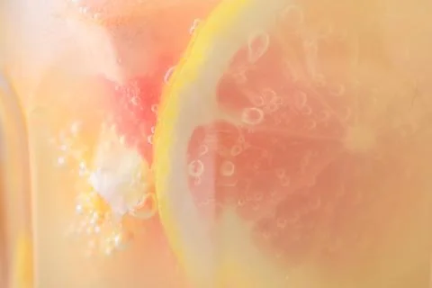 Summer refreshing lemonade close up. Macro photo of a citrus cocktail in a li Stock Photos