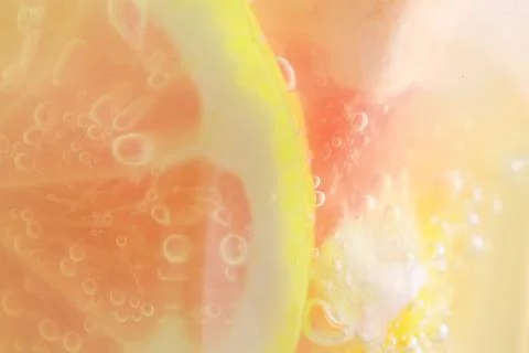 Summer refreshing lemonade close up. Macro photo of a citrus cocktail in a li Stock Photos