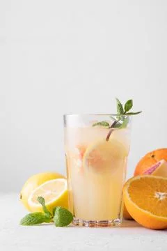 Summer refreshing lemonade with mint on a light background. A glass of citrus Stock Photos