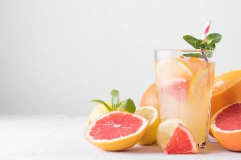 Summer refreshing lemonade with mint on a light background. A glass of citrus Stock Photos