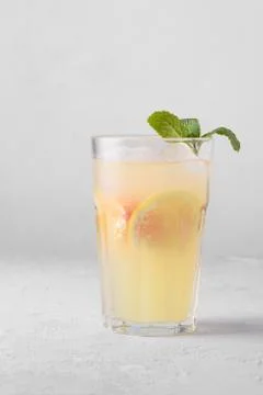 Summer refreshing lemonade with mint on a light background. A glass of citrus Stock Photos