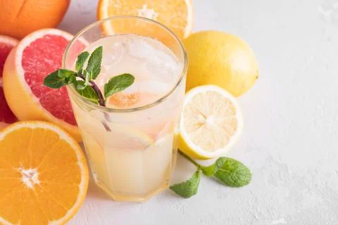 Summer refreshing lemonade with mint on a light background. A glass of citrus Stock Photos