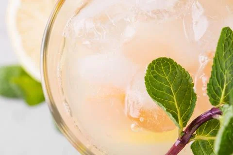 Summer refreshing lemonade with mint on a light background. A glass of citrus Stock Photos