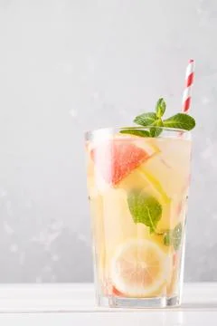 Summer refreshing lemonade with mint on a light background. A glass of citrus Stock Photos