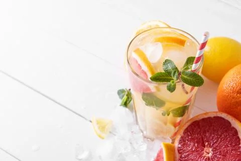 Summer refreshing lemonade with mint on a light background. A glass of citrus Stock Photos