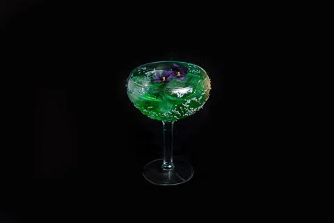 Summer refreshment drinks. Light green cocktail, on dark background. With flo Stock Photos