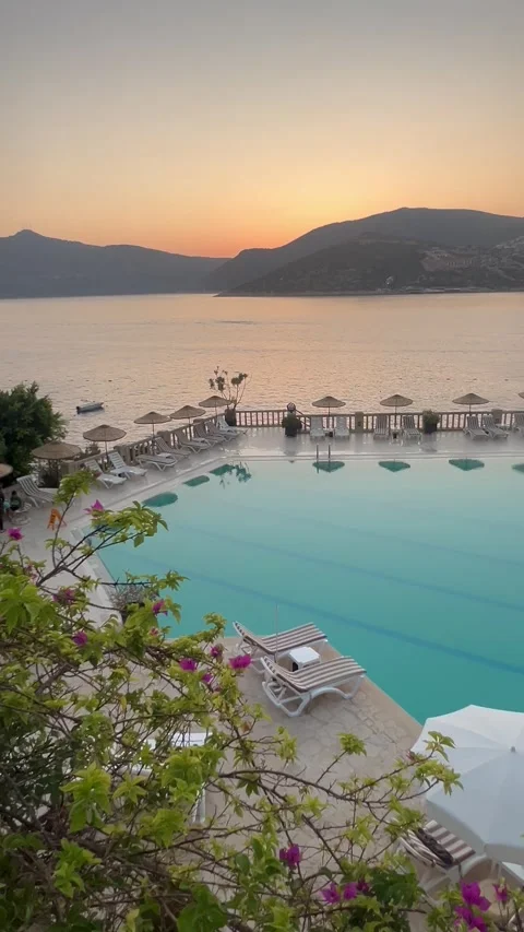 Summer resort with pool in front of the sea by sunset Stock Footage 336904913