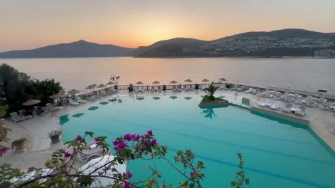 Summer resort with pool in front of the sea by sunset Stock Footage 336904927