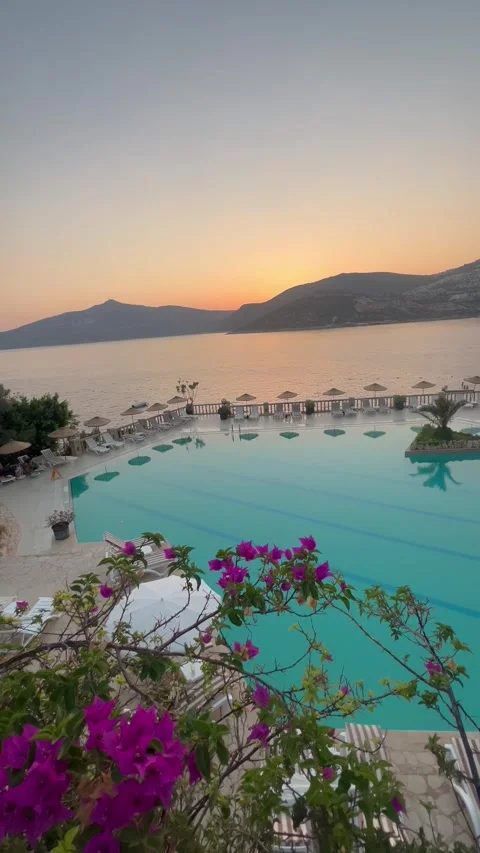 Summer resort with pool in front of the sea by sunset Stock Footage 336974971