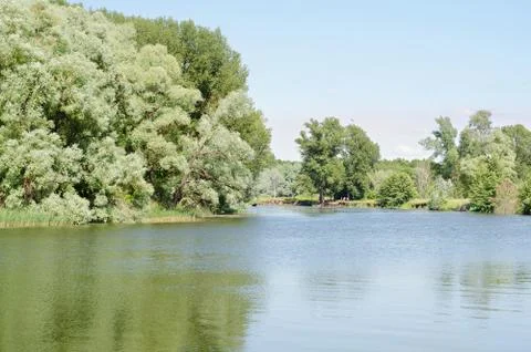 Summer river landscape under a blue sky, people relax in the distance on the Фото