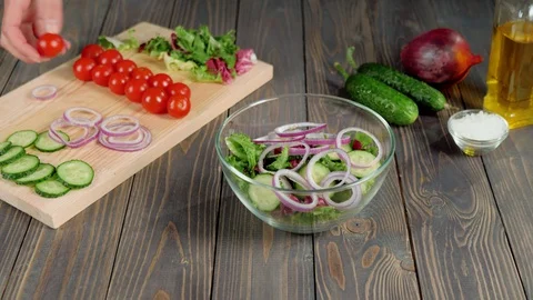 Summer salad. Professional chef pours fresh juicy cherry tomatoes in glass bowl Stock Footage 129746432