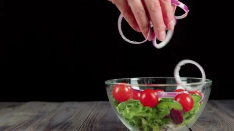 Summer salad. Professional chef pours sliced purple onion in glass bowl Stock Footage 130516161