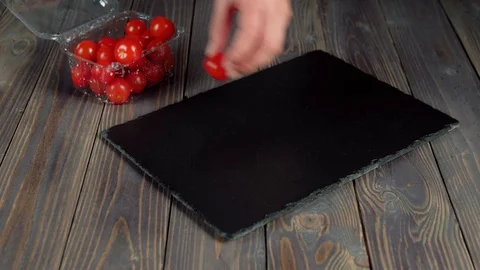Summer salad. Woman's hand put out from a plastic container with cherry tomatoes Stock Footage 129745581