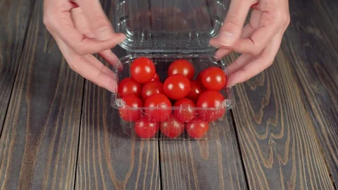 Summer salad. Woman's hands turn over a plastic container with cherry tomatoes Stock Footage 129745371