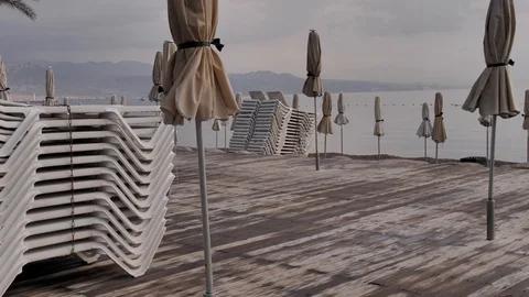 Summer scene with empty resort beach and many sunbeds and closed umbrellas. All Stock Footage 127068487