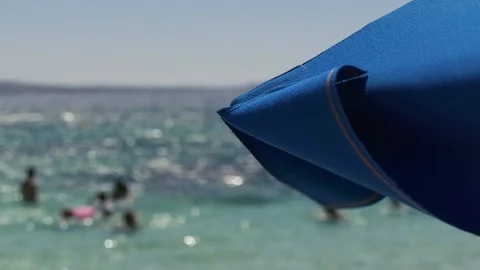 Summer scene of umbrella in the wind on beach Stock Footage 129433152