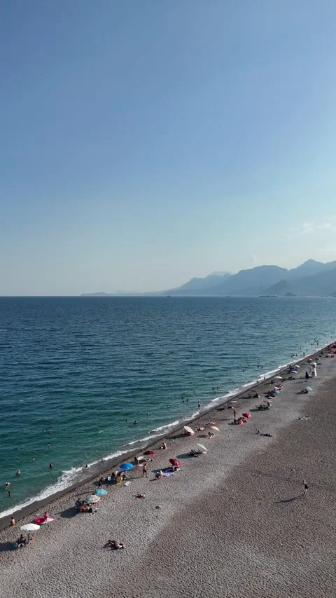 Summer scenery with people sunbathing at the beach by the sea Stock Footage 342286596