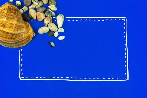 Summer sea flat lay composition with seashell and pebbles on a blue backgroun Stock Photos