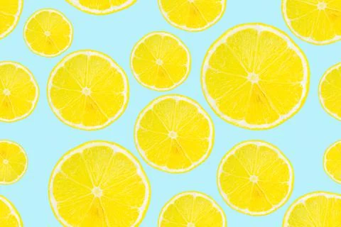 Summer seamless pattern. Lemon slices on a light blue background. Stock Photos